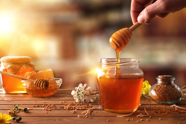 Hand-with-dipper-picking-honey-from-a-jar-1