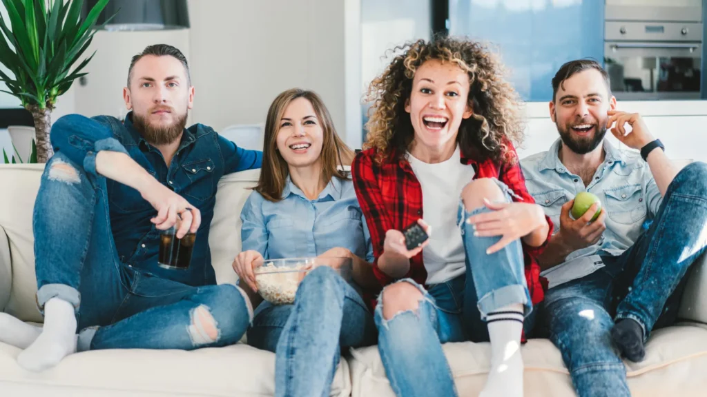 young-people-friends-watch-tv-on-sofa-in-living-room